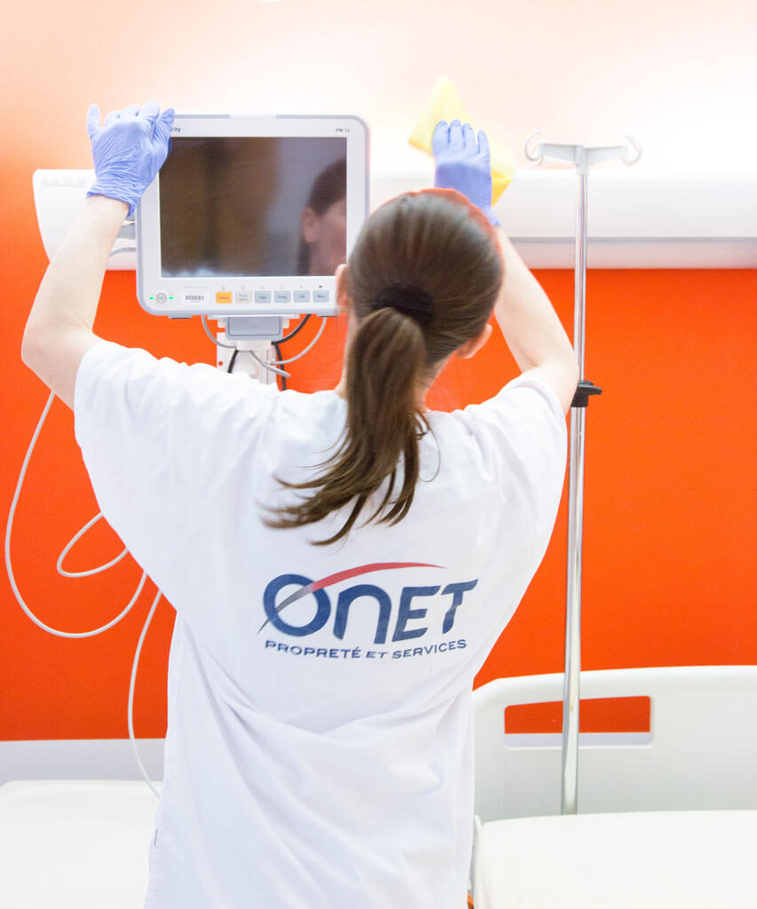 Profesional de Onet limpiando entorno hospitalario: sostenibilidad social y empleo de calidad